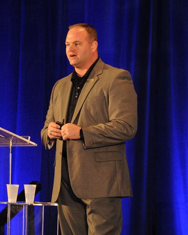 Ben Tobias speaking on a conference stage.